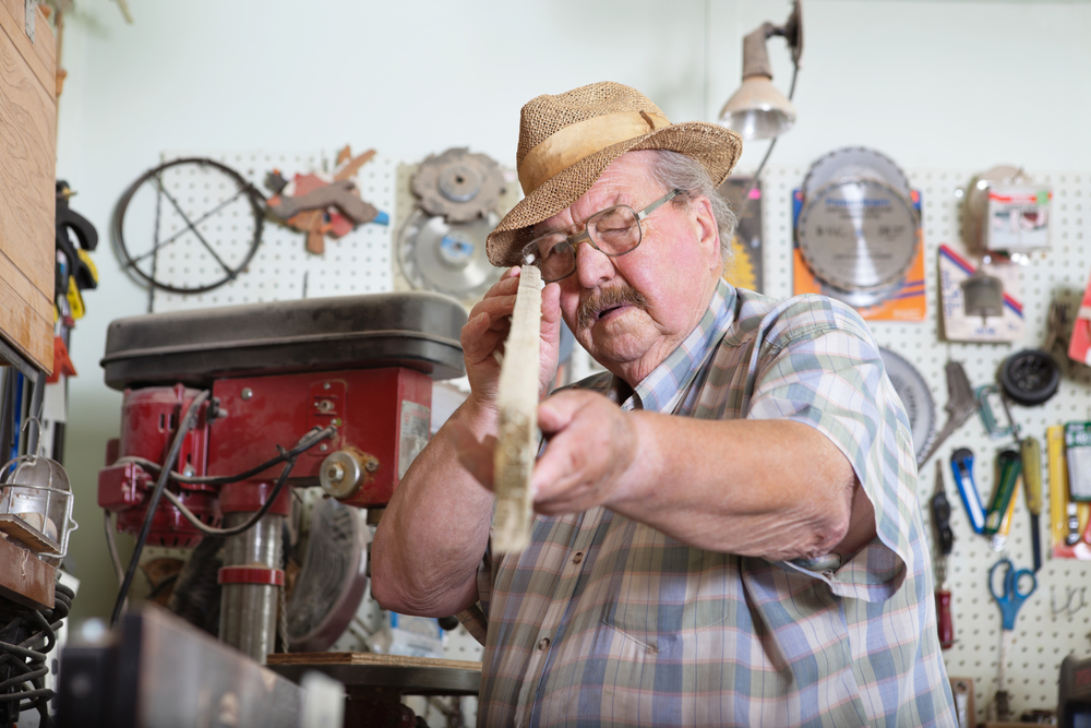 Portrait of senior man holding wooden plank