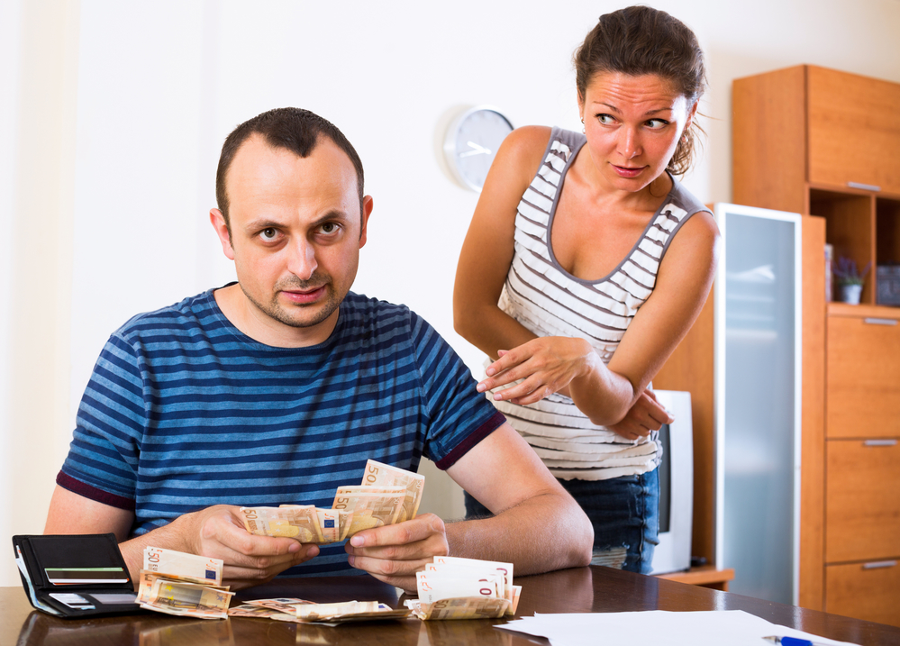 Young woman and her husband counting money for paying debts