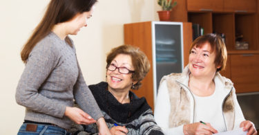 Portrait of positive mature women with papers and agency employee