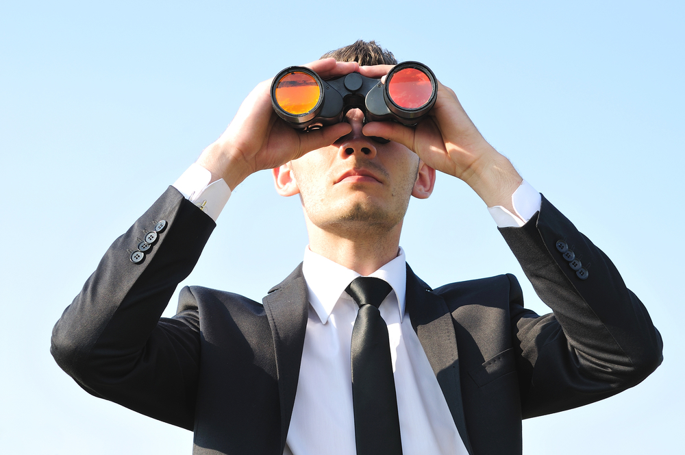 Business man with binoculars on sky