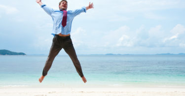 Funny business man jumping on the beach