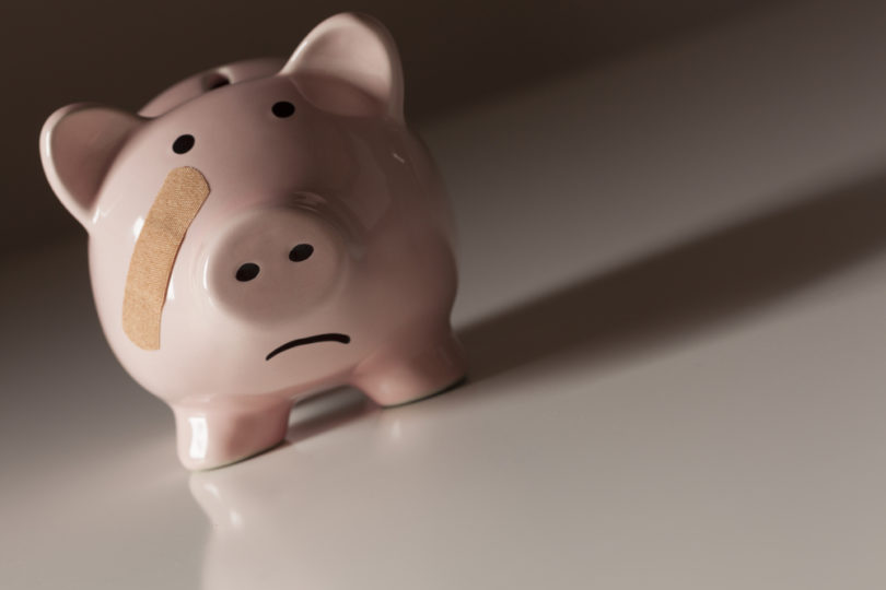 Piggy Bank with Bandage on Face on Dramatic Gradated Background.