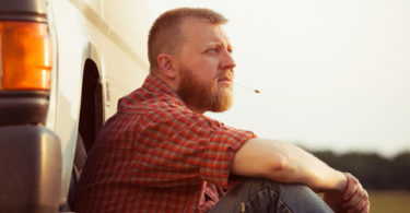 Red-bearded man in jeans on a summer evening