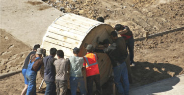 builders pushing the cable bobbin