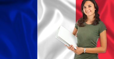 Smiling young female student  over French flag