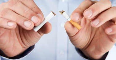 Human hands breaking up cigarette