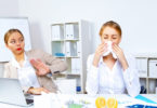 Young woman feeling unwell and sick in office