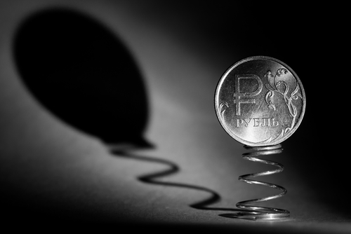 Coin one ruble on the spring casts a shadow in the form of a balloon. Black and white photo closeup