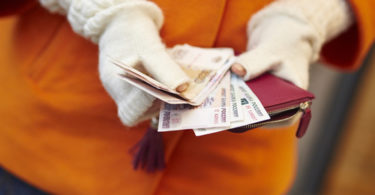 Woman hands holding purse with Russian roubles, financial crisis in Russia concept