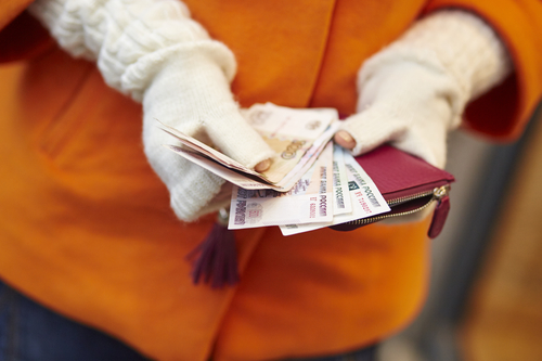 Woman hands holding purse with Russian roubles, financial crisis in Russia concept