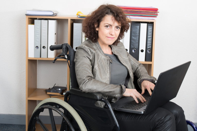 Disabled woman in wheelchair with a laptop working