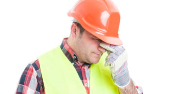 Portrait of stressed male builder looking upset and having problems isolated on white background