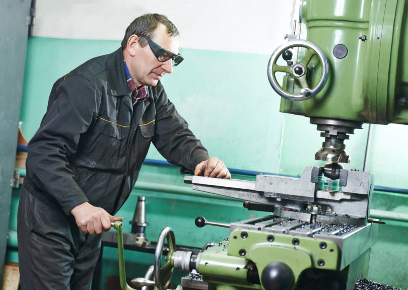 milling machine operator working in factory workshop