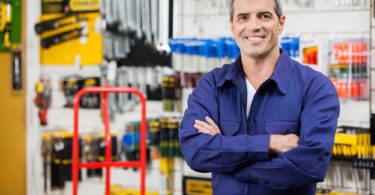 Portrait of confident worker with arms crossed standing in hardware shop