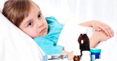 Sick little beautiful girl with red scarf in the bed