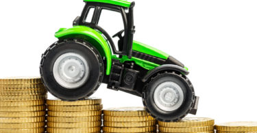 farmers in agriculture have to reckon with rising costs. higher preies in feed, fertilizer and plants. tractor with coins