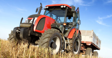 Agriculture - tractor on the field with harvested corn