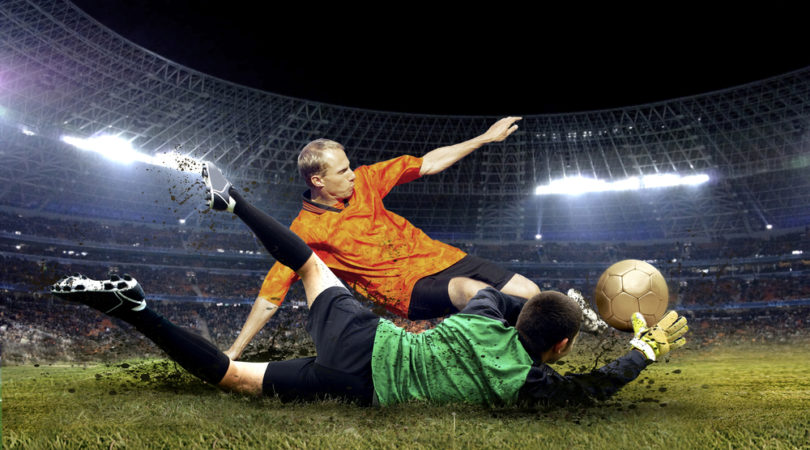 Football player and jump of goalkeeper on the field of stadium at night