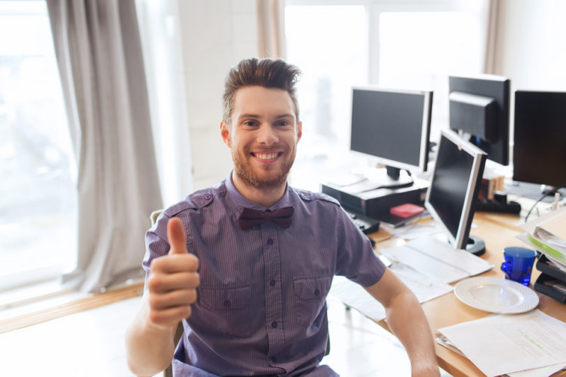 business, startup, gesture and people concept - happy businessman or creative male office worker with computers showing thumbs up