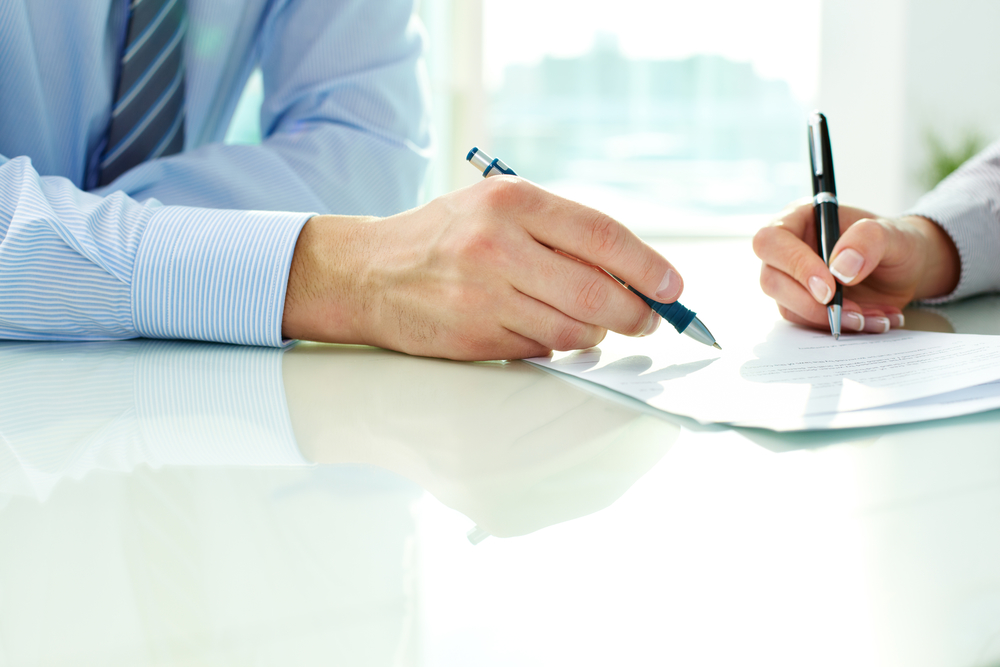 Two business partners signing a document