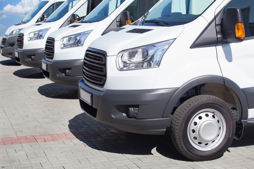 number of new white minibuses and vans outside