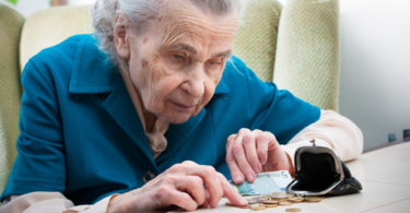 elderly caucasian woman counting money  on table