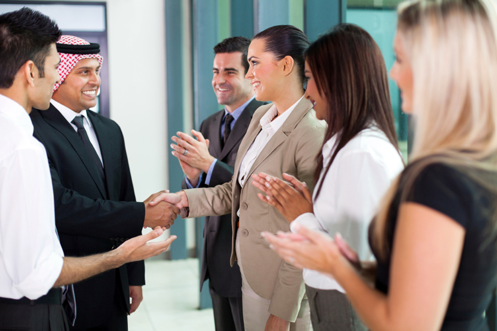 young translator introducing arab businessman to group of businesspeople