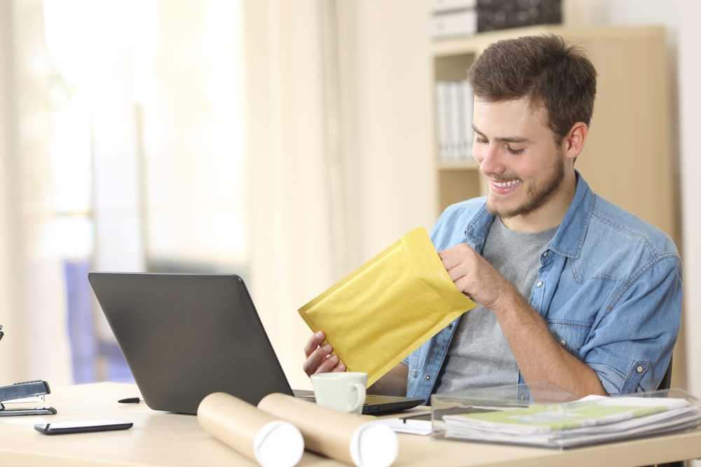 Entrepreneur opening a padded envelope