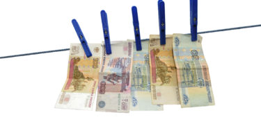 Russian rubles banknotes hanging on laundry line attached with plastic clothespins against white background