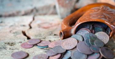 Ancient clay mug full of old coins. The treasure was found in an old building