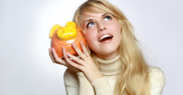 Beautiful woman with a piggy bank