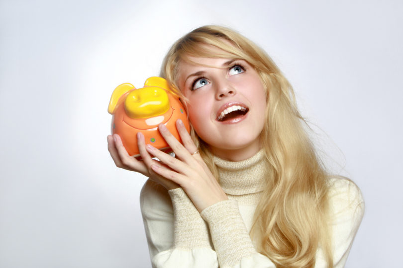 Beautiful woman with a piggy bank