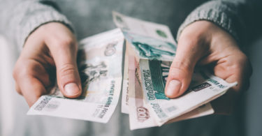 Hands holding russian rouble bills. Toned picture