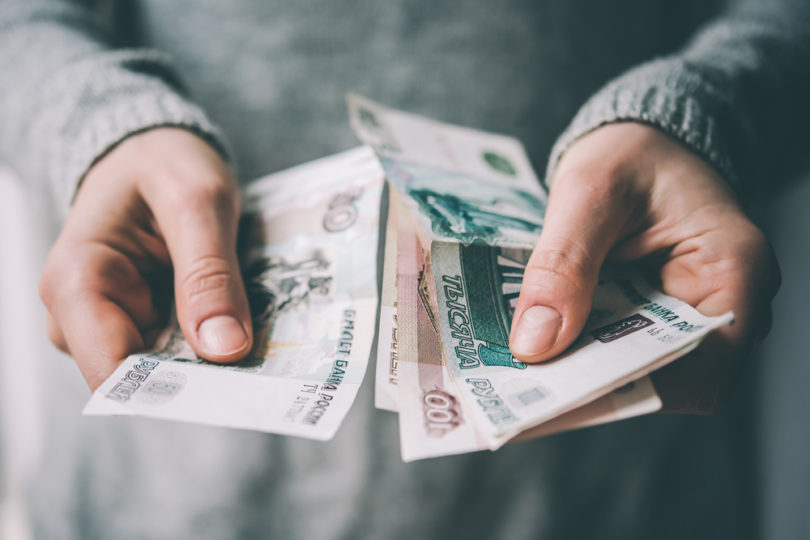 Hands holding russian rouble bills. Toned picture