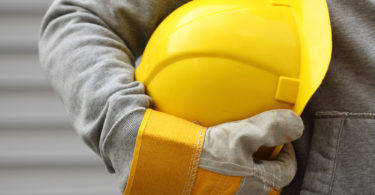 Man holding yellow helmet close up