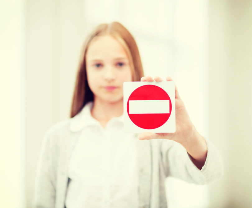 education, school and anti-bullying concept - student girl showing no entry sign