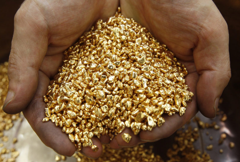 A worker scoops gold shots at Japanese jewellery brand, Ginza Tanaka's original equipment manufacturer (OEM) factory in the Chiba prefecture, east of Tokyo September 14, 2009. Gold prices erased earlier gains and fell on Monday, as the dollar rebounded on short-covering and dragged down other commodities and equities.  REUTERS/Yuriko Nakao (JAPAN BUSINESS IMAGES OF THE DAY)