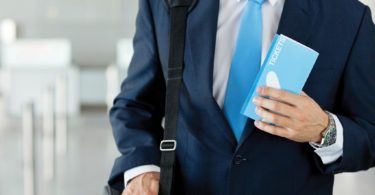 Businessman Holding Airplane Ticket At Airport